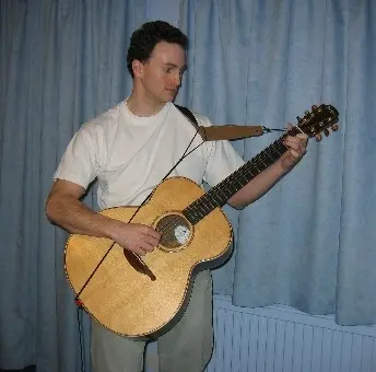 holding a guitar while standing